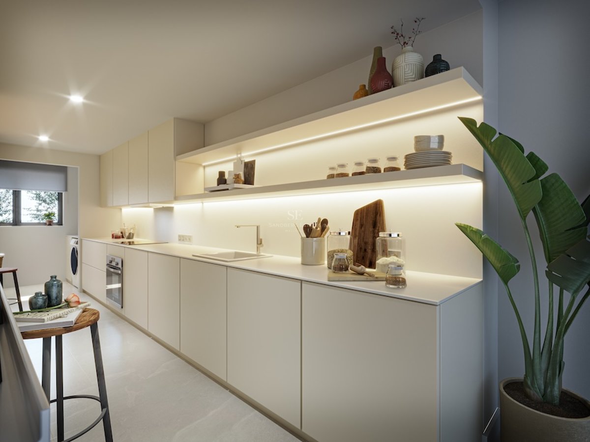 Cuisine moderne beige avec de longs plans de travail, étagères ouvertes éclairées par LED et une grande plante verte.