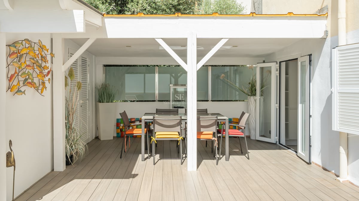 Grande piscine bordée de transats, avec une maison moderne au design minimaliste à l'arrière-plan et une végétation luxuriante.