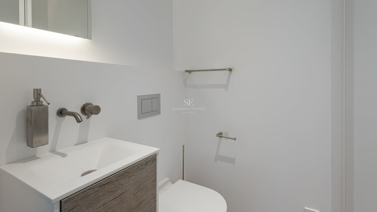 Vasque blanche moderne avec robinetterie en acier brossé et meuble en bois texturé.