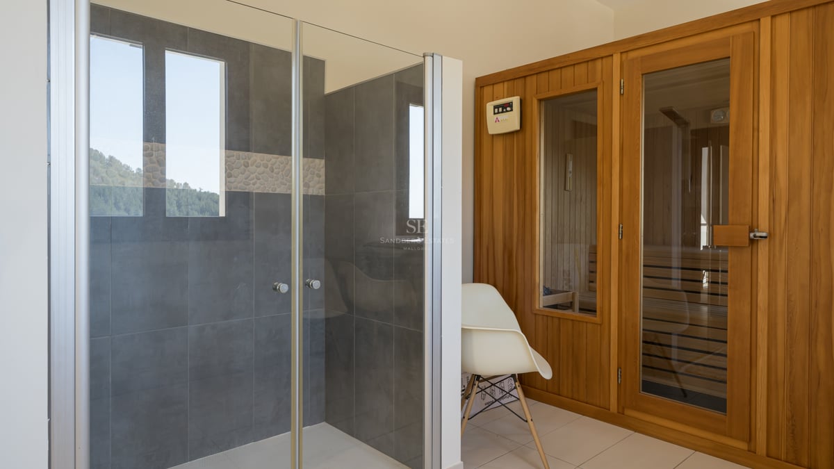 Espace spa avec douche vitrée, carrelage gris et sauna en bois naturel au design contemporain.