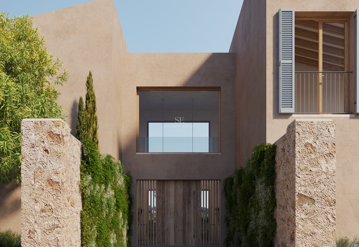 Entrée d'une villa moderne avec une grande porte en bois, des murs couleur sable et des colonnes en pierre naturelle.
