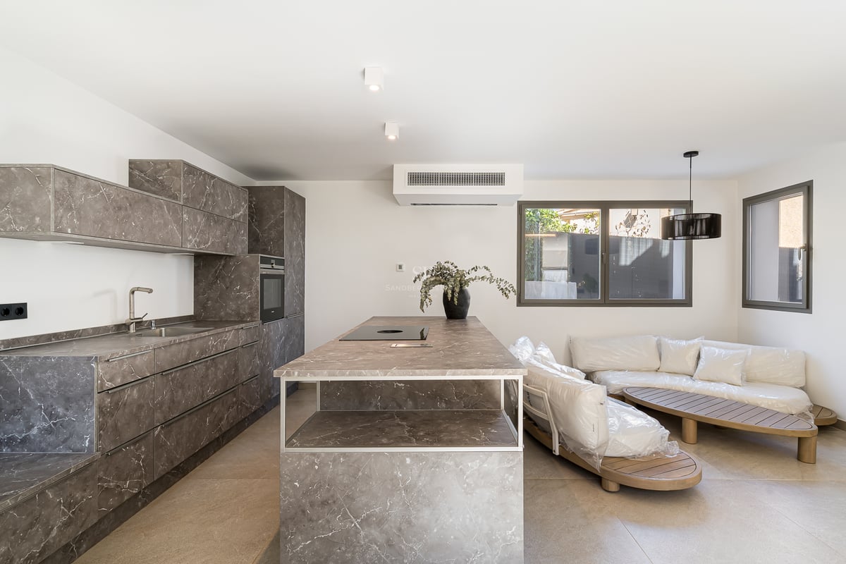 Cuisine contemporaine avec meubles effet marbre gris, îlot central et appareils électroménagers intégrés.