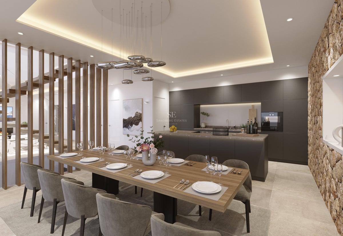 Une salle à manger moderne avec une table en bois, des chaises grises et une cuisine noire avec un mur en pierre.