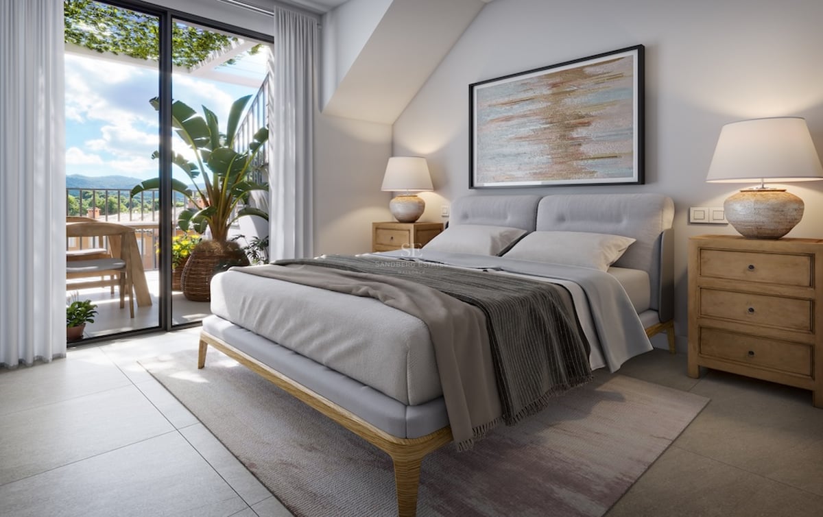 Chambre principale moderne avec grand lit, tables de chevet en bois et baies vitrées ouvrant sur une terrasse ensoleillée.