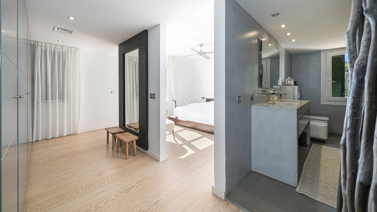 Suite parentale moderne avec parquet en chêne, vasque en béton ciré et placards intégrés blancs.