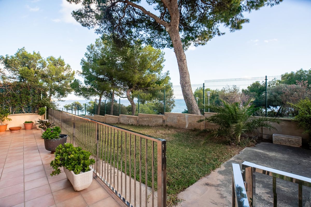Terrasse en terre cuite surplombant un jardin privé avec des pins et une vue sur la mer Méditerranée.