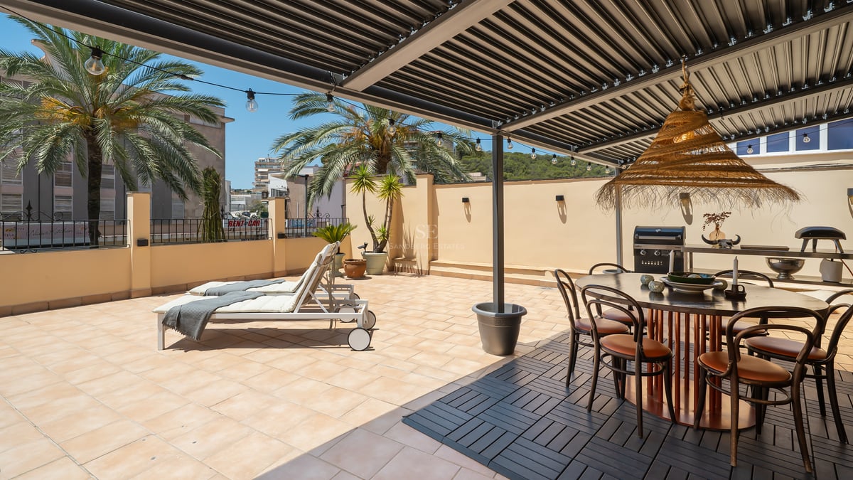 Terrasse ensoleillée avec pergola bioclimatique, salle à manger extérieure, barbecue et bains de soleil.