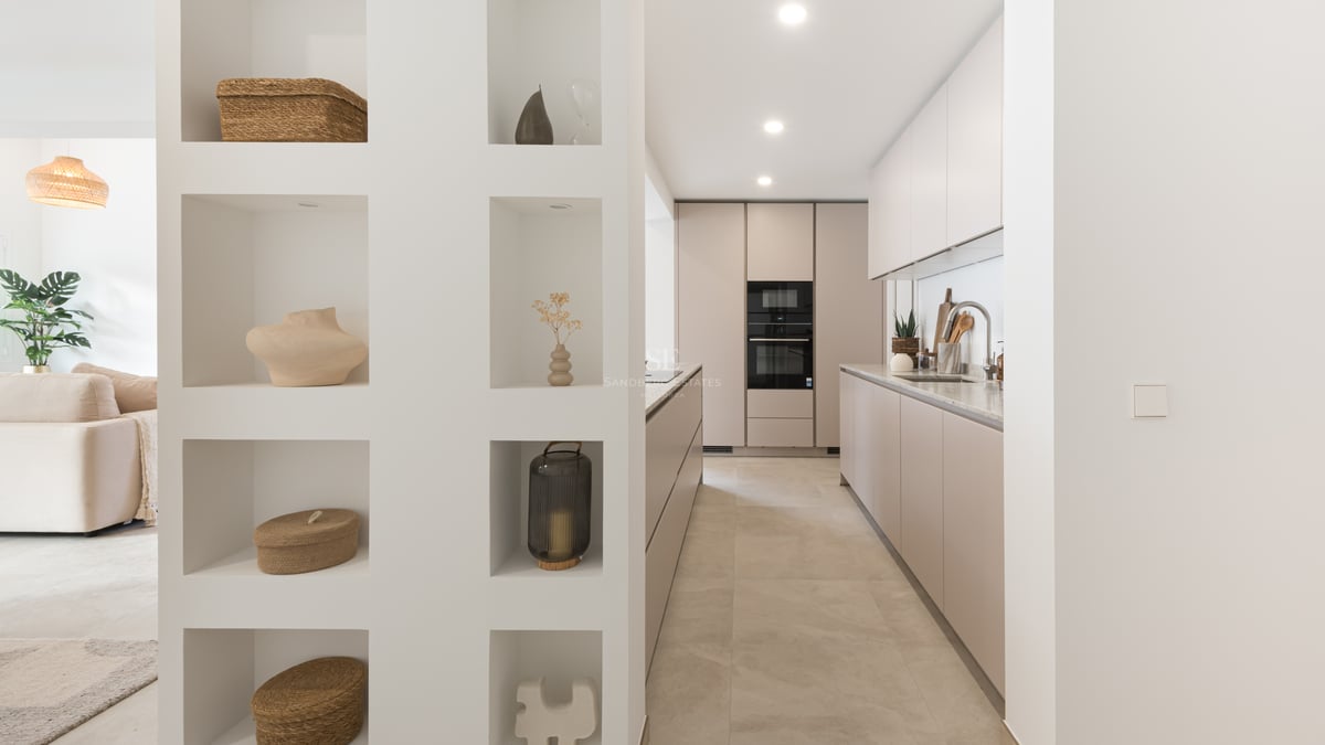 Cuisine moderne avec des meubles taupe et un mur comprenant des niches décoratives avec des objets d'art.