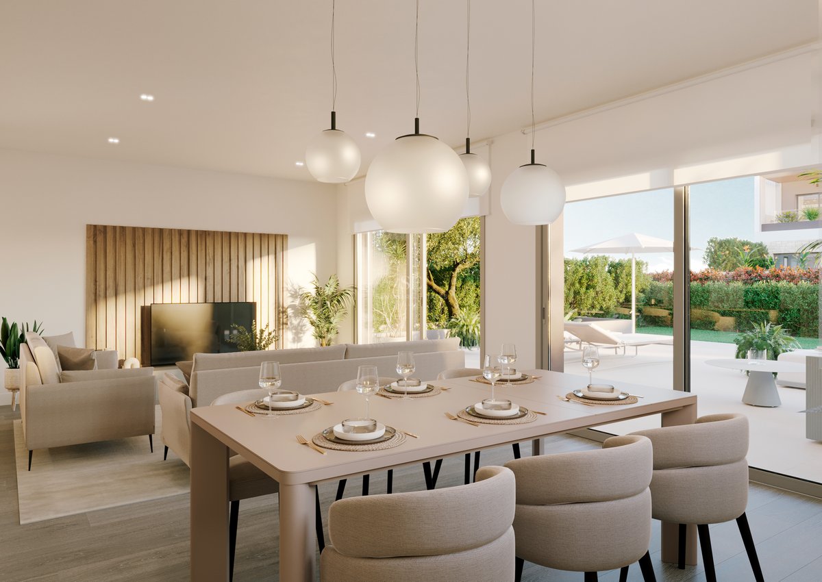 Comedor moderno con sillas beige y lámparas esféricas que da a una terraza soleada con jardín.