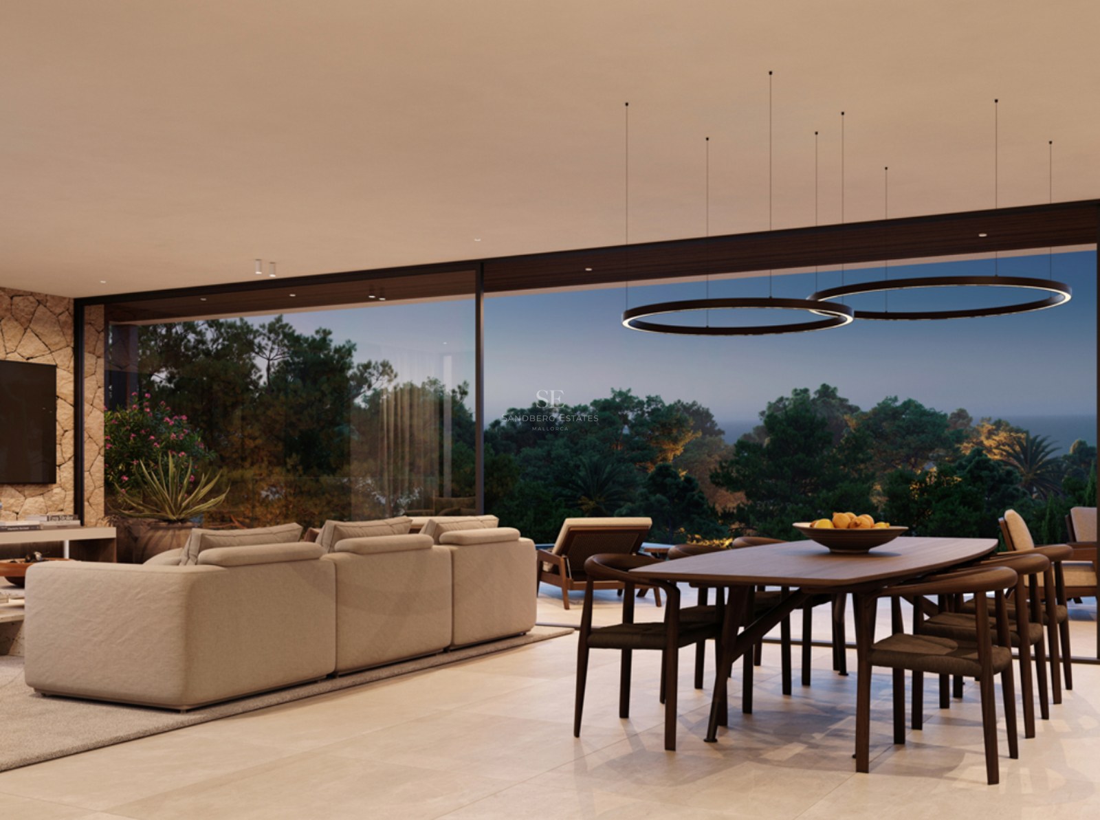 A spacious modern living room with a large sofa, wooden dining set, and floor-to-ceiling windows overlooking trees.