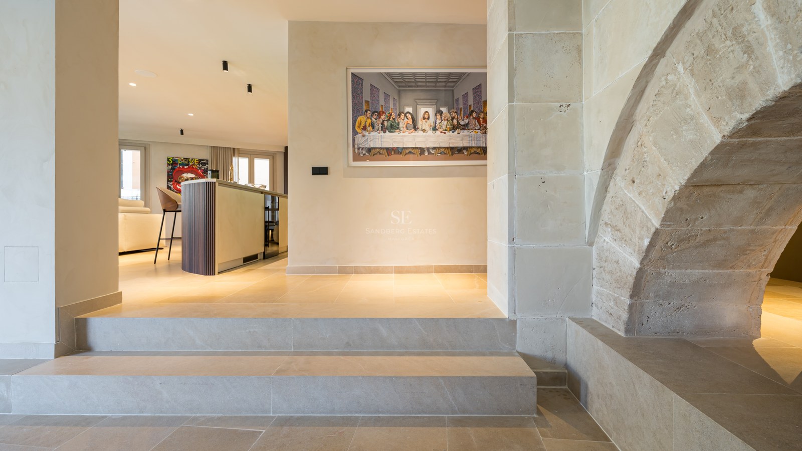 Interior entrance featuring stone steps, a rustic stone arch, and a modern kitchen in the background.