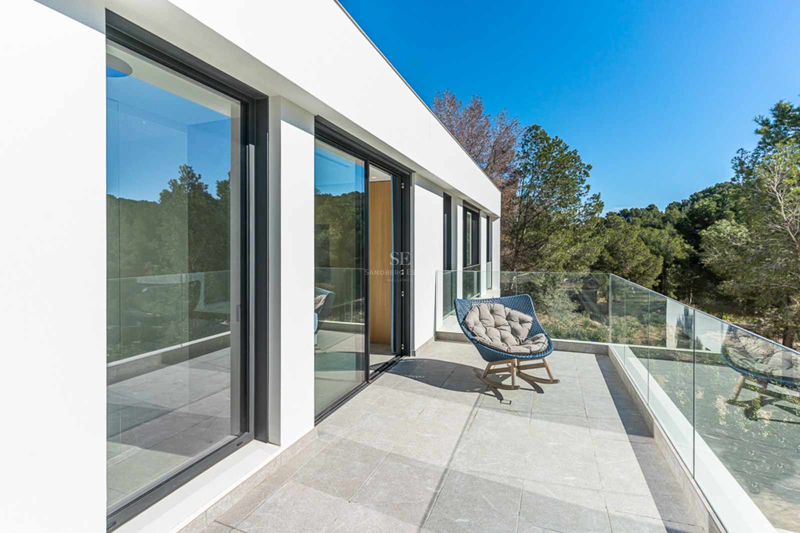 Exteriörvy av en modern villa med pool. Minimalistisk arkitektur, stora fönster och frodig trädgårdsdesign.