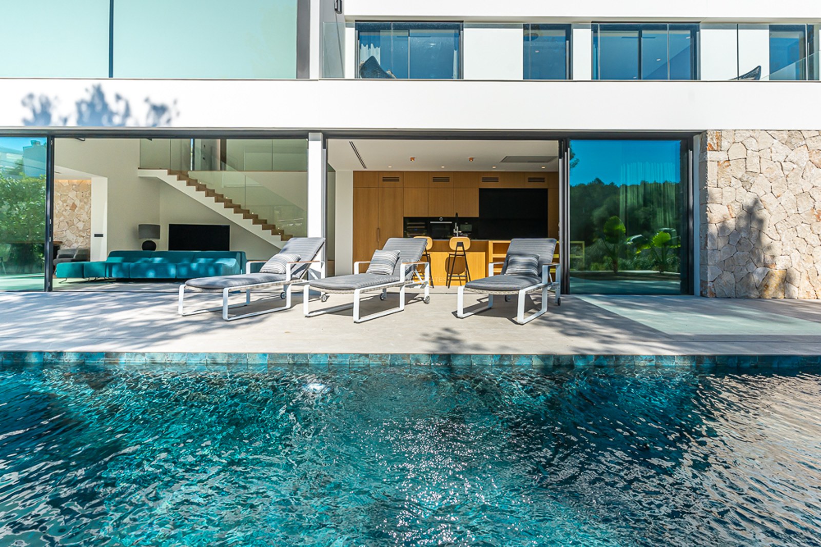 Poolvy med infinitypool och solstolar. Modern design, palmer, blå himmel. Lyx och komfort. Avkoppling vid poolen.