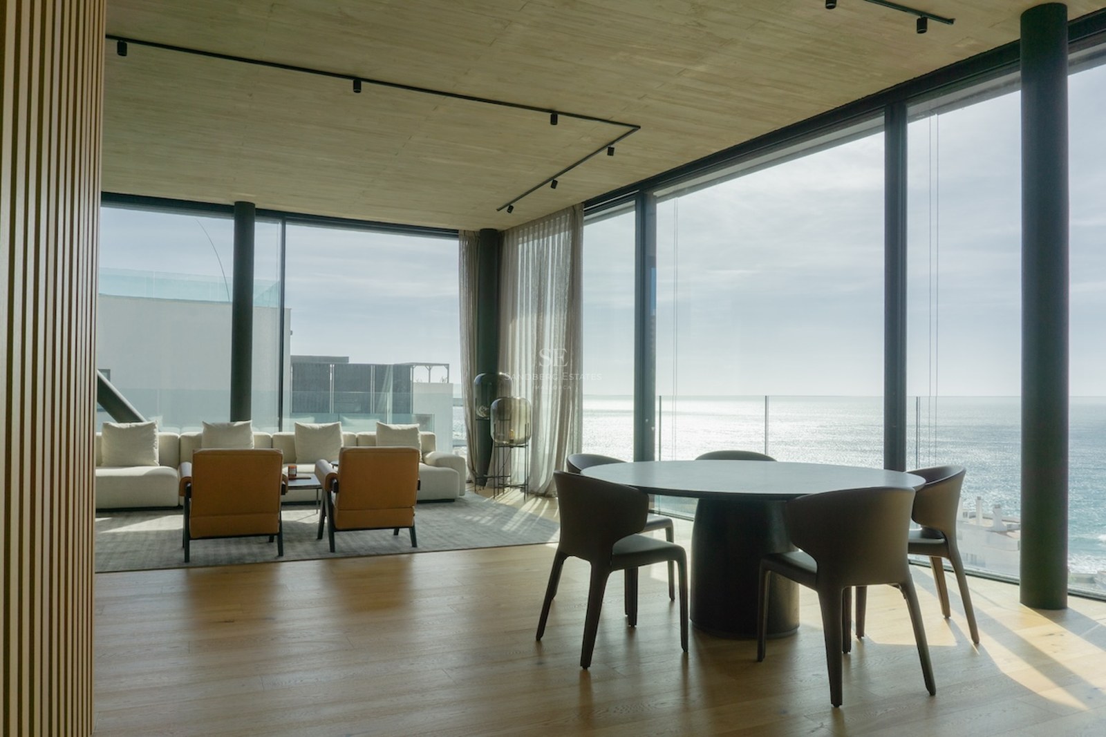 Moderner Essbereich mit rundem Tisch und bodentiefen Glasfronten mit Blick auf das Mittelmeer.