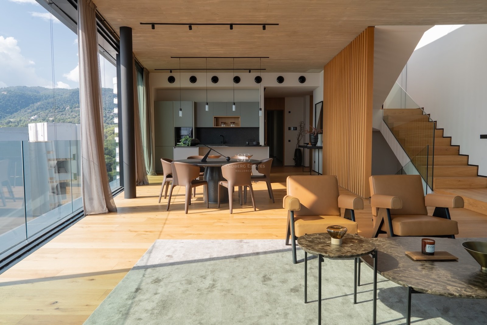 Großzügiges modernes Wohnzimmer mit Eichenparkett, bodentiefe Fenster mit Bergblick und Designerküche.