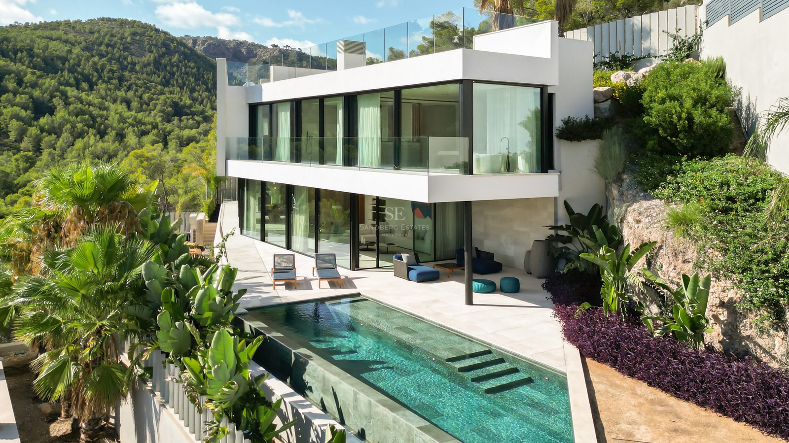 Exterior of a modern house with a pool and garden. Minimalist architecture, large windows, natural light and high-end finishes.