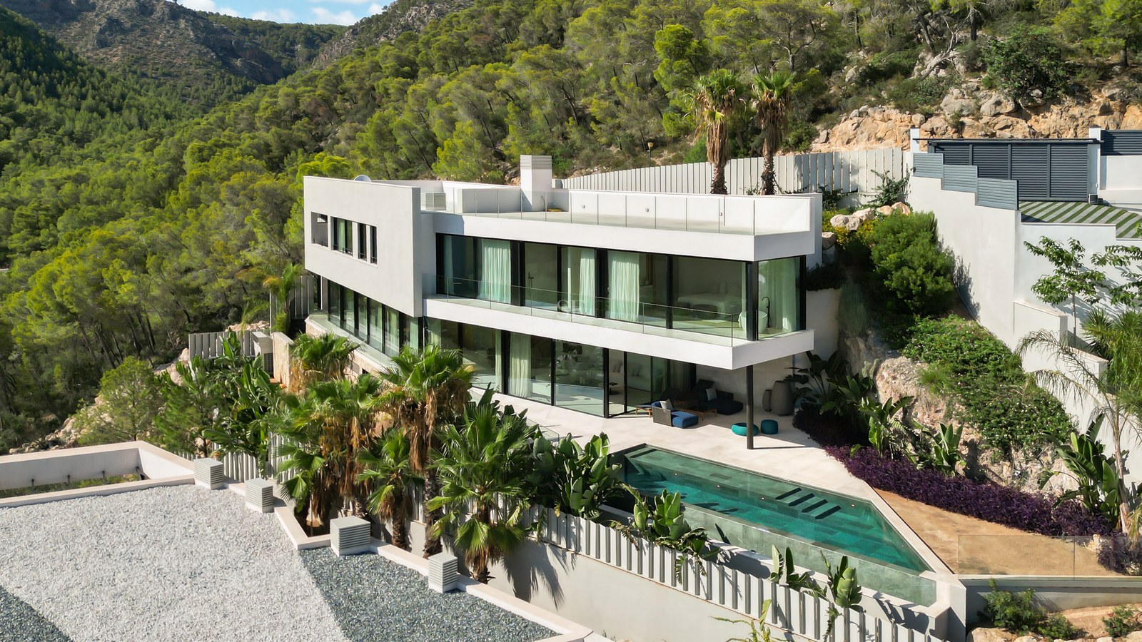 Exterior view of a luxurious villa with infinity pool, lush garden and modern architecture. Ideal investment opportunity.