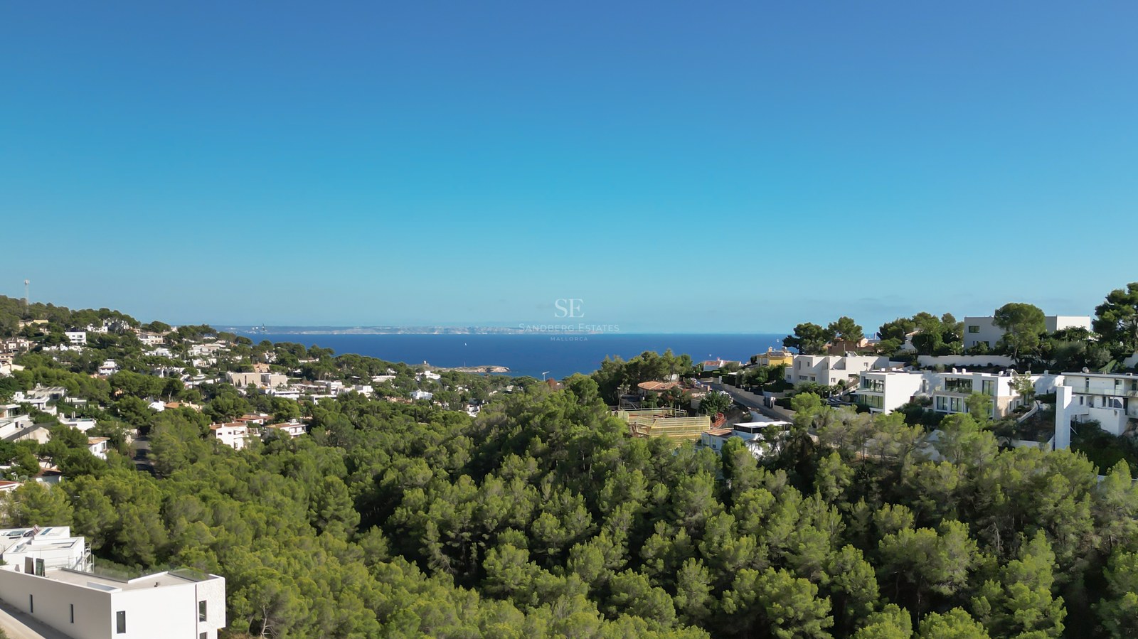 Spacious balcony with panoramic sea views. Glass railing, wooden floor and elegant outdoor furniture.