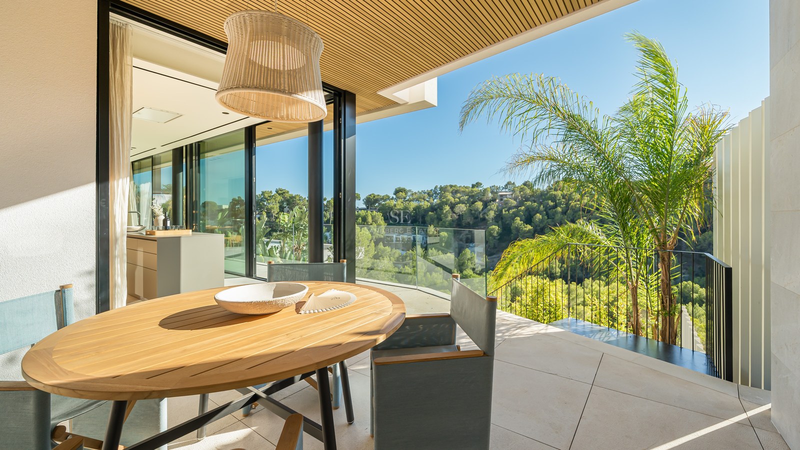 View of a modern infinity pool, surrounded by a wooden deck and lush greenery. Minimalist architecture and natural light.