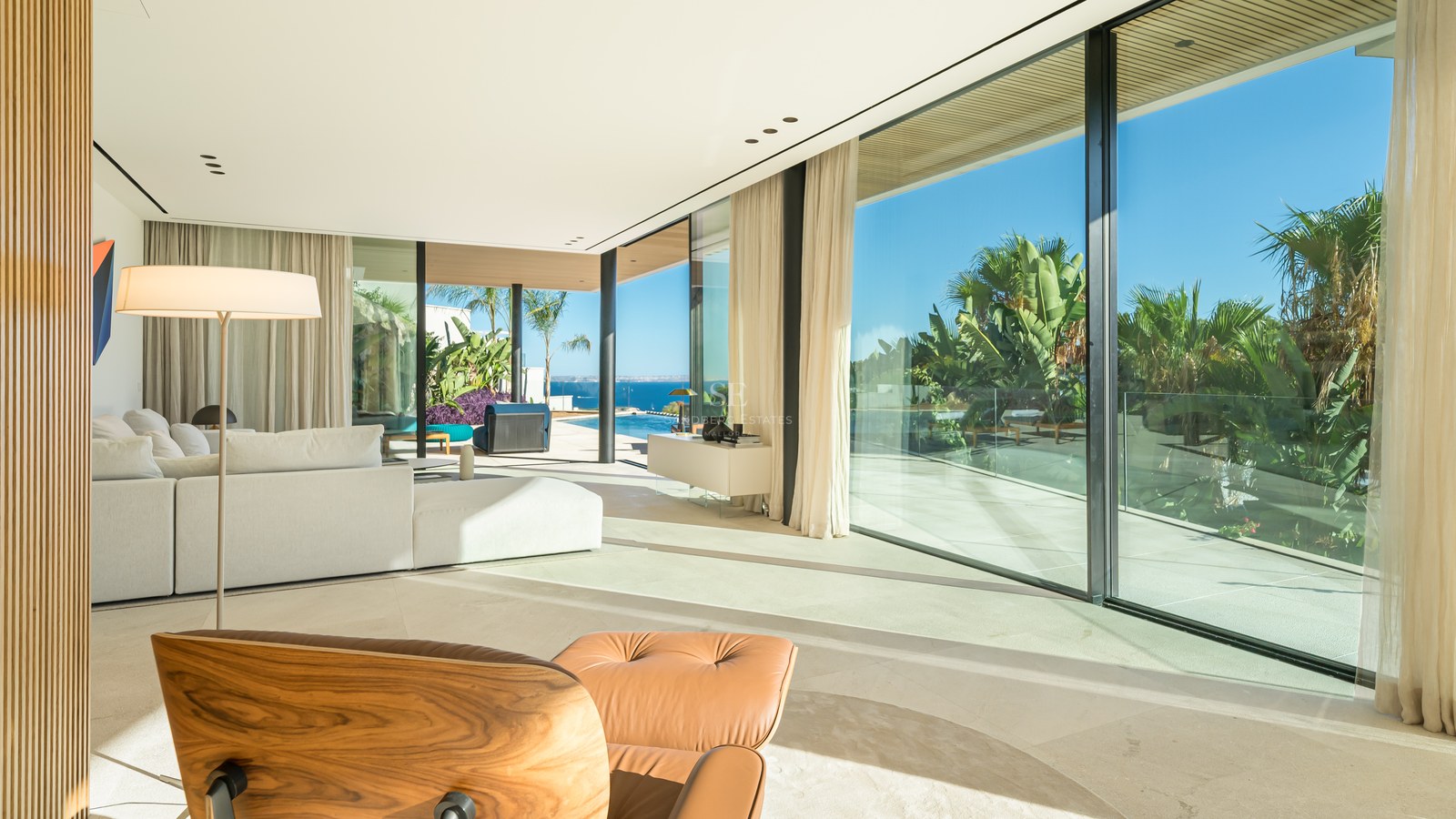 Terrace view with infinity pool and ocean view. Modern design, elegant outdoor furniture, and manicured landscaping.