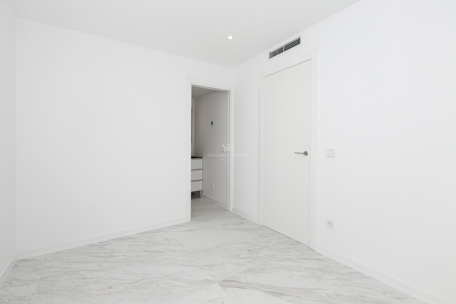 Bright empty room with white walls, polished grey-veined marble floors, and modern white doors.