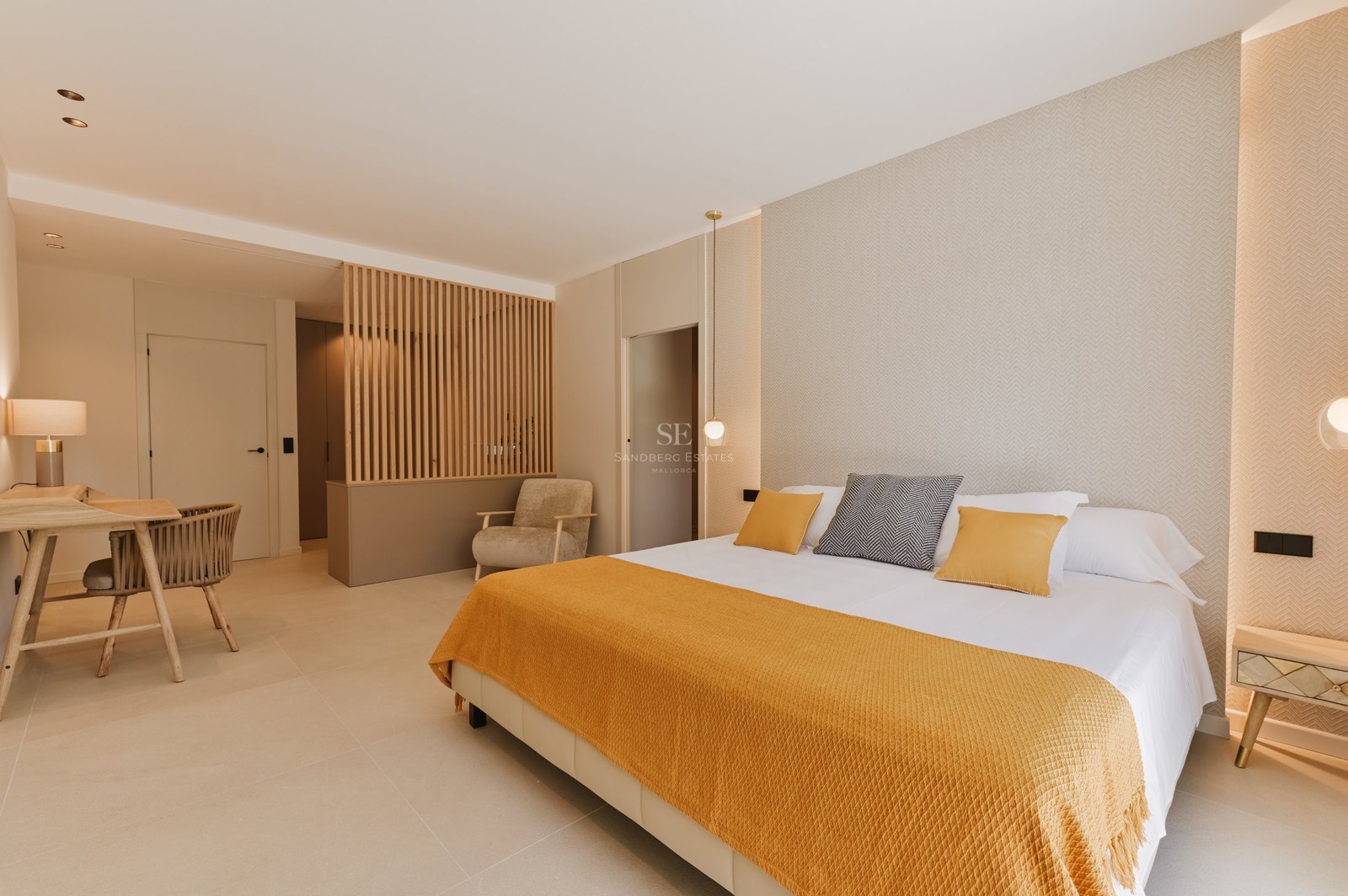 Dormitorio moderno con cama doble, manta ocre y divisor de ambientes de listones de madera en tonos neutros.