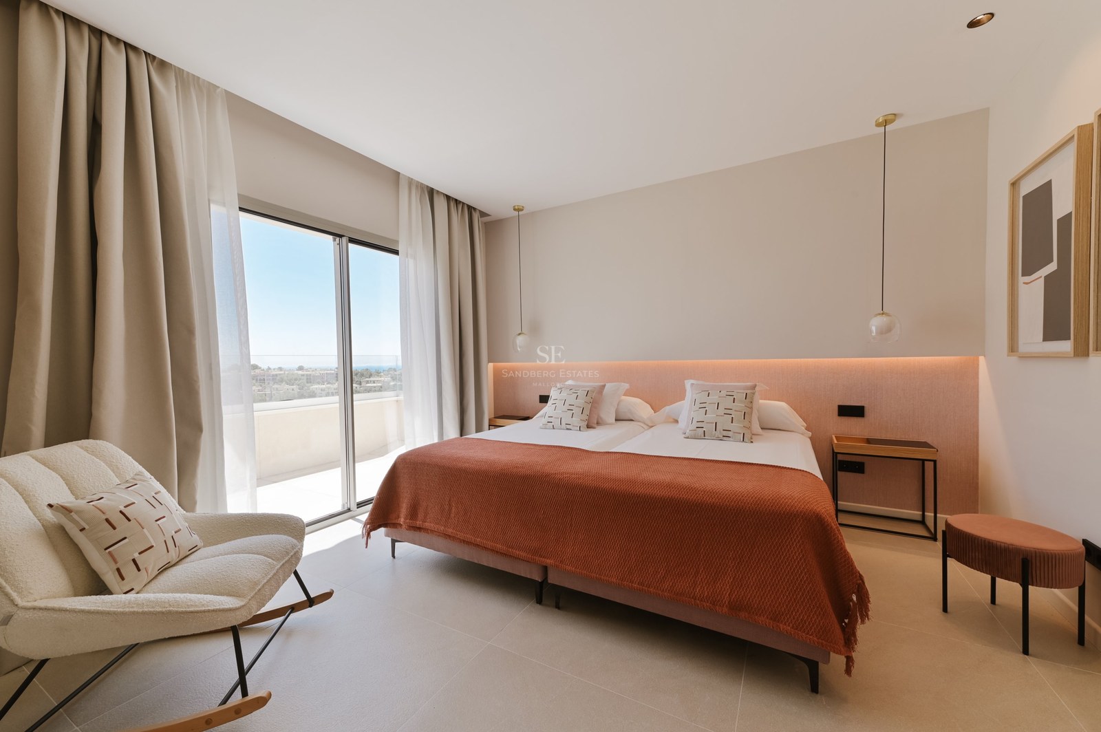 Dormitorio moderno con cama terracota, iluminación indirecta y ventanales de suelo a techo hacia una terraza soleada.