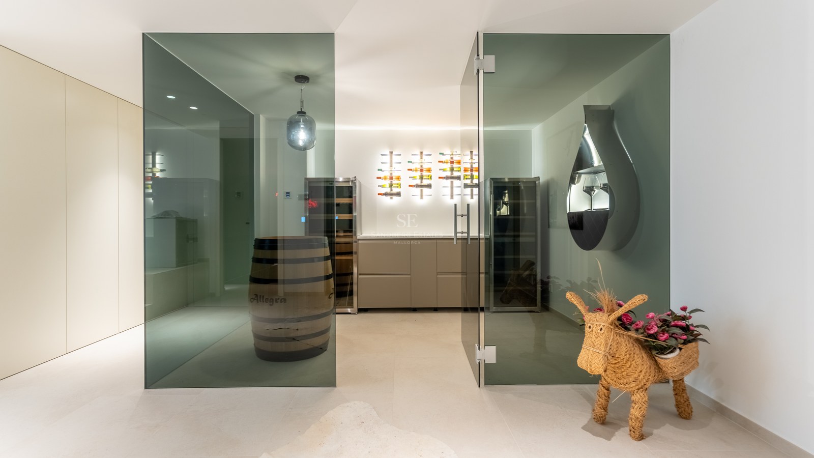 Contemporary wine cellar with glass doors, backlit bottle racks, climate cabinets, and a decorative wooden barrel.