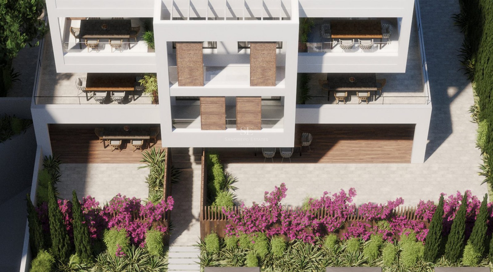 High-angle view of a white modern building featuring spacious terraces and lush Mediterranean landscaping.