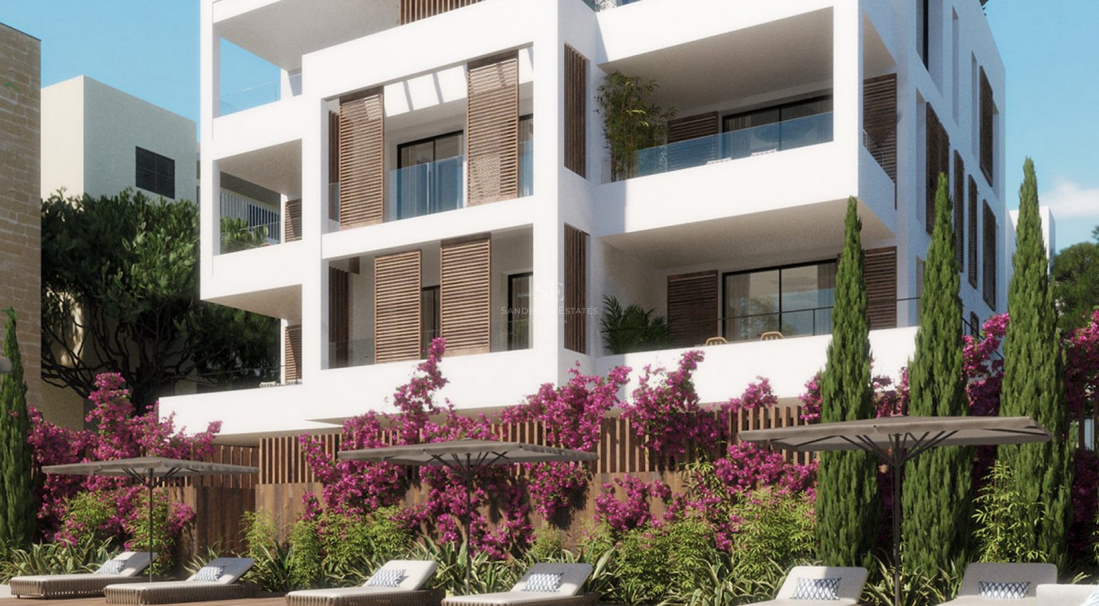 White modern building with wooden shutters, glass balconies, and pink bougainvillea flowers by a lounge area.