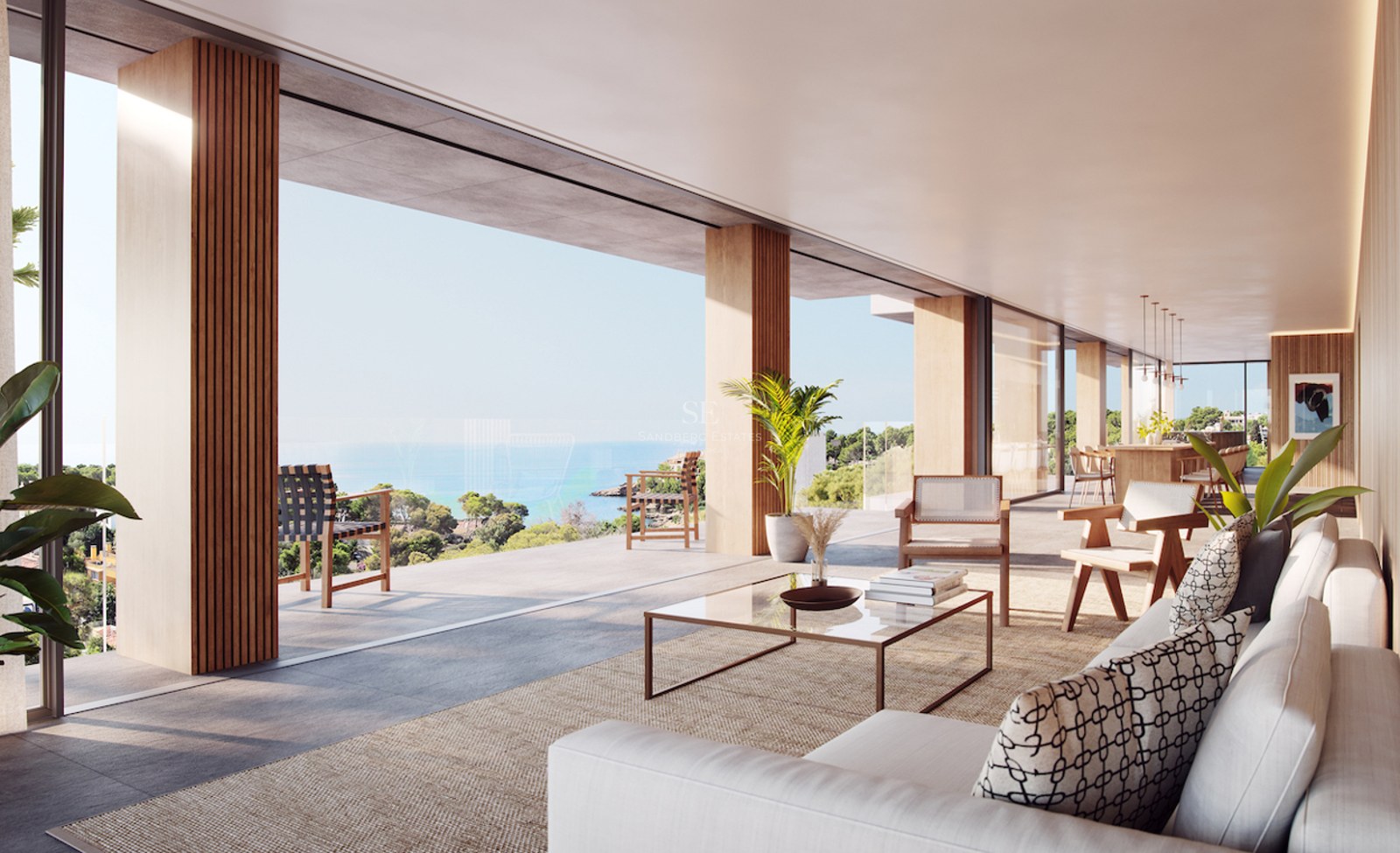 Modern open-plan living room with floor-to-ceiling windows opening to a terrace overlooking the ocean and coast.