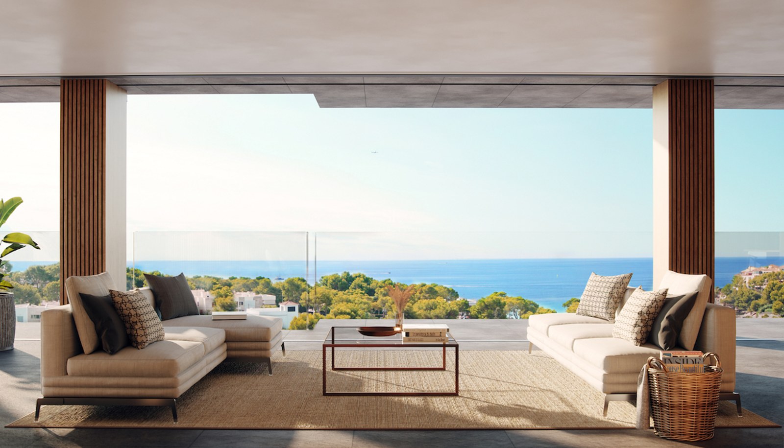 Modern terrace with beige sofas and glass railing overlooking the Mediterranean Sea and lush greenery.