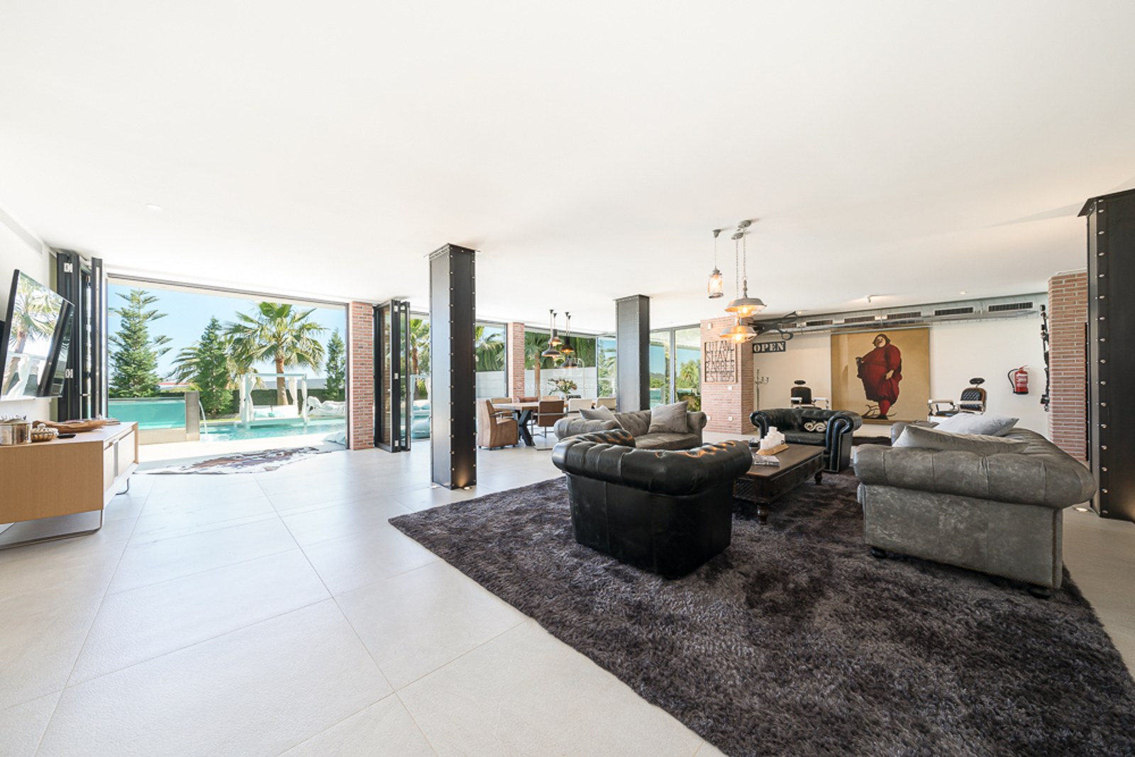 Vue aérienne d'une villa moderne avec piscine bleu vif, jardin luxuriant et architecture minimaliste. Vastes terrasses et abondance de lumière naturelle.