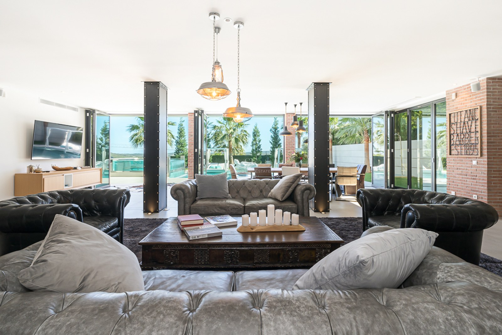 Vue panoramique d'une villa moderne avec piscine, jardin et vastes terrasses. Architecture minimaliste avec des lignes épurées et beaucoup de lumière naturelle.