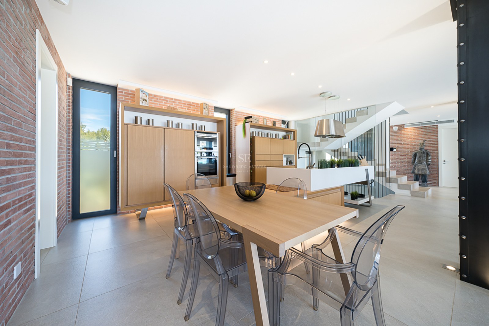 Vue panoramique d'un balcon luxueux avec piscine à débordement et vue sur la mer. Design moderne avec mobilier élégant et végétation luxuriante.
