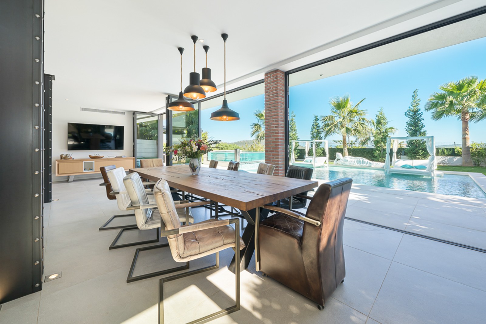 Vue extérieure d'une villa moderne avec piscine réfléchissante, jardin luxuriant et design architectural minimaliste.