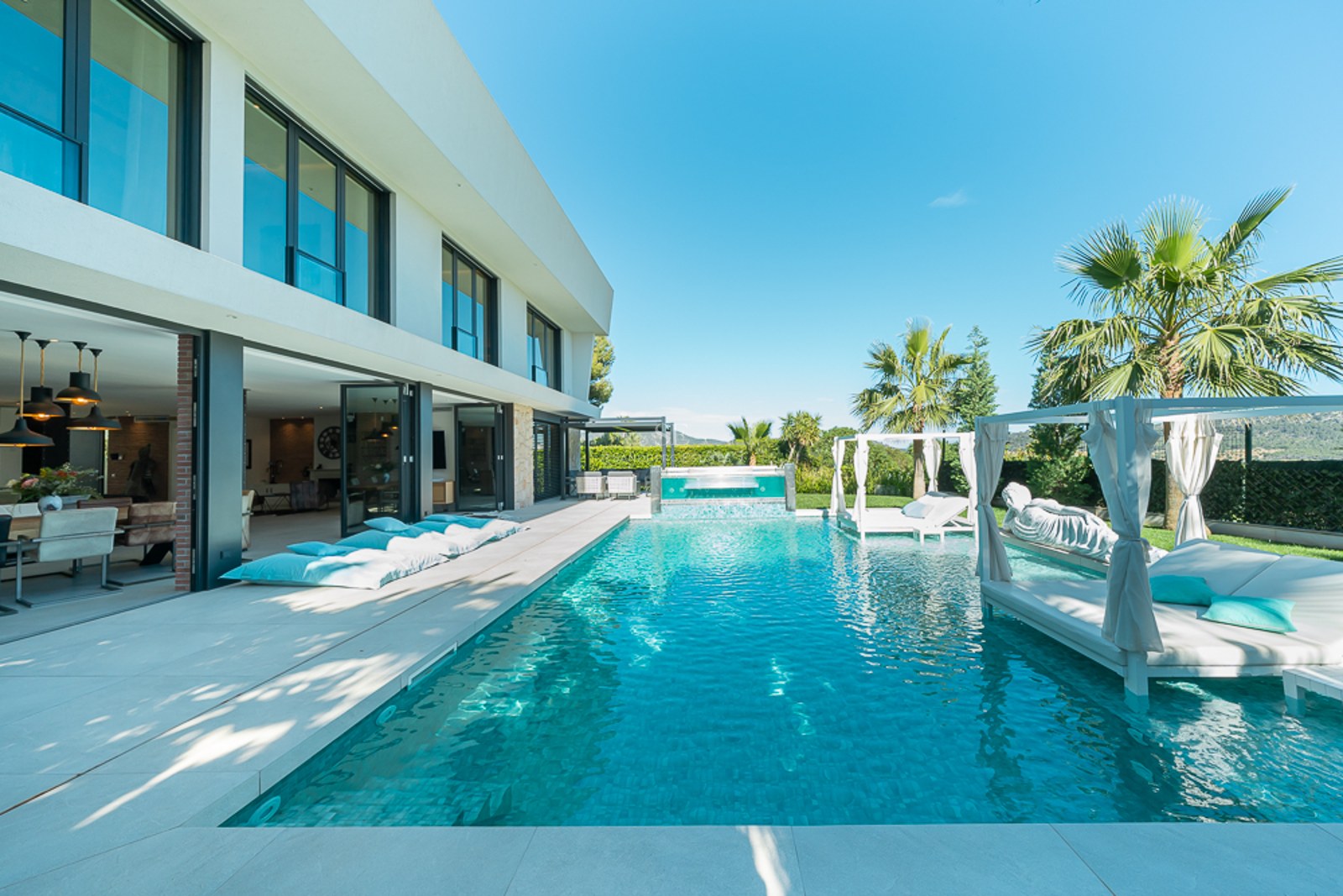 Vue extérieure d'une villa moderne avec piscine, jardin et vastes terrasses. Design élégant et finitions de haute qualité.