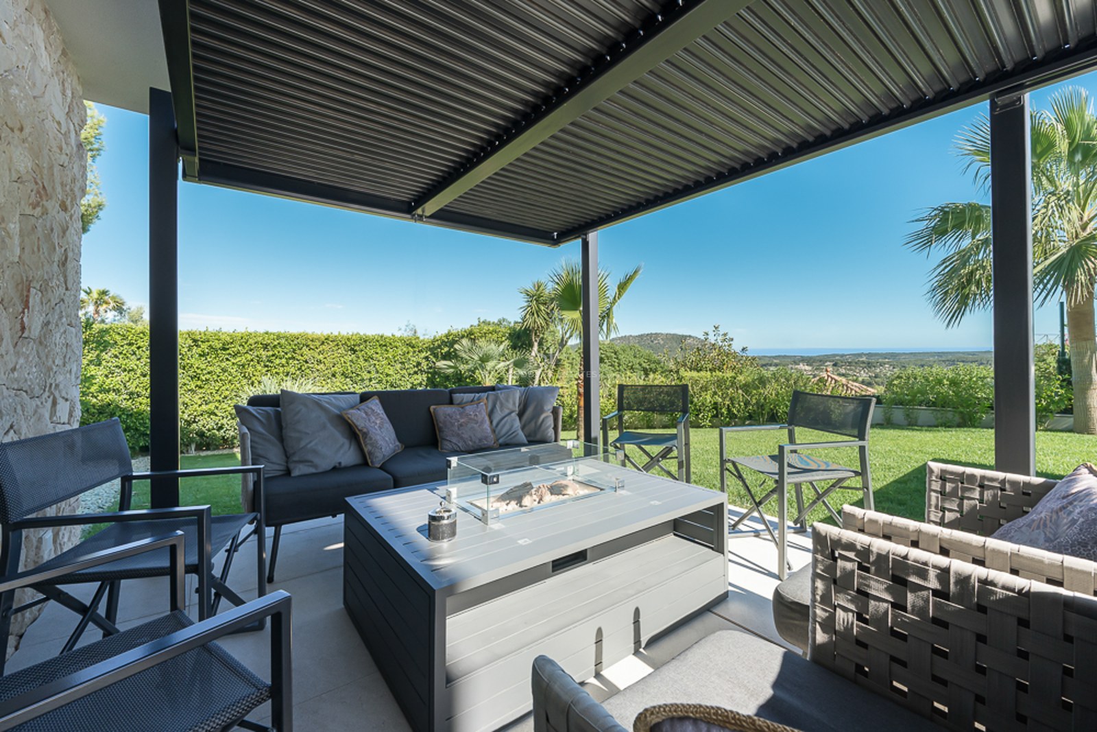 Grand balcon offrant une vue panoramique sur la mer. Design moderne, minimaliste avec garde-corps en verre et mobilier d'extérieur.