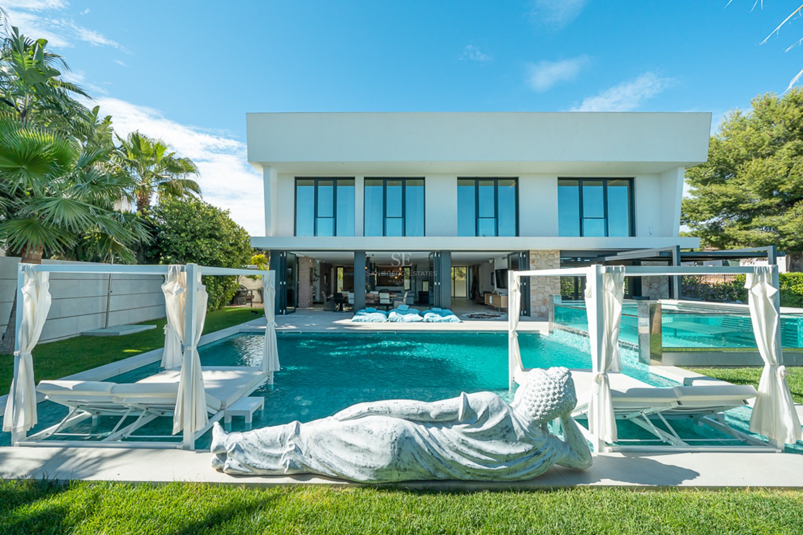 Vue extérieure d'une maison moderne avec piscine. Architecture minimaliste, grandes fenêtres, jardin soigné. Éclairage ambiant.