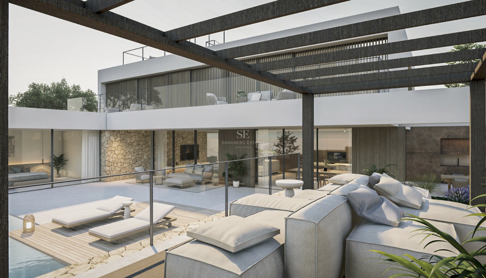 Terrasse de villa moderne avec canapés gris, chaises longues, pergola sombre et murs en pierre naturelle.