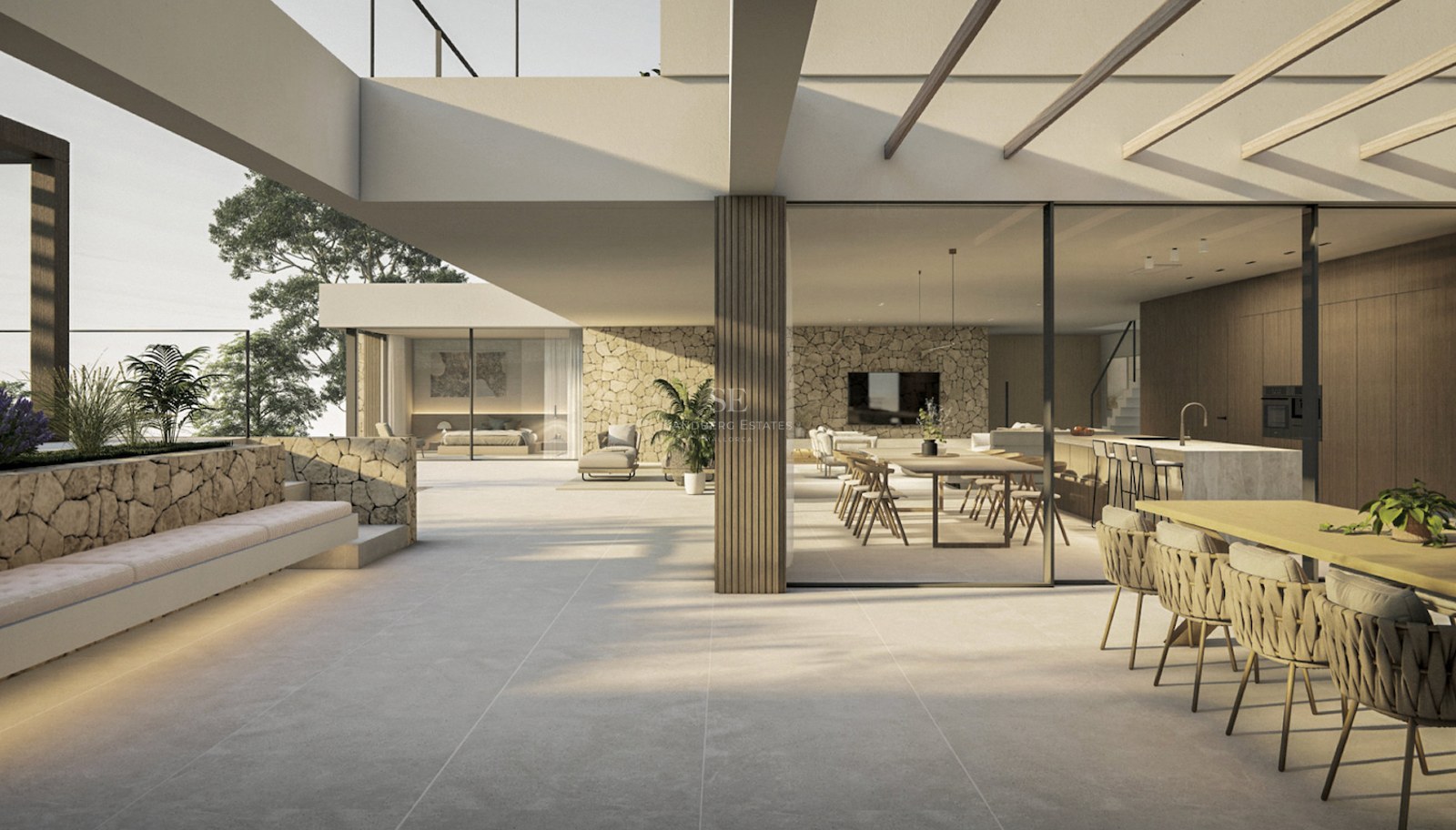 Terrasse de villa moderne avec murs en pierre et baies vitrées s'ouvrant sur un grand salon et une salle à manger.
