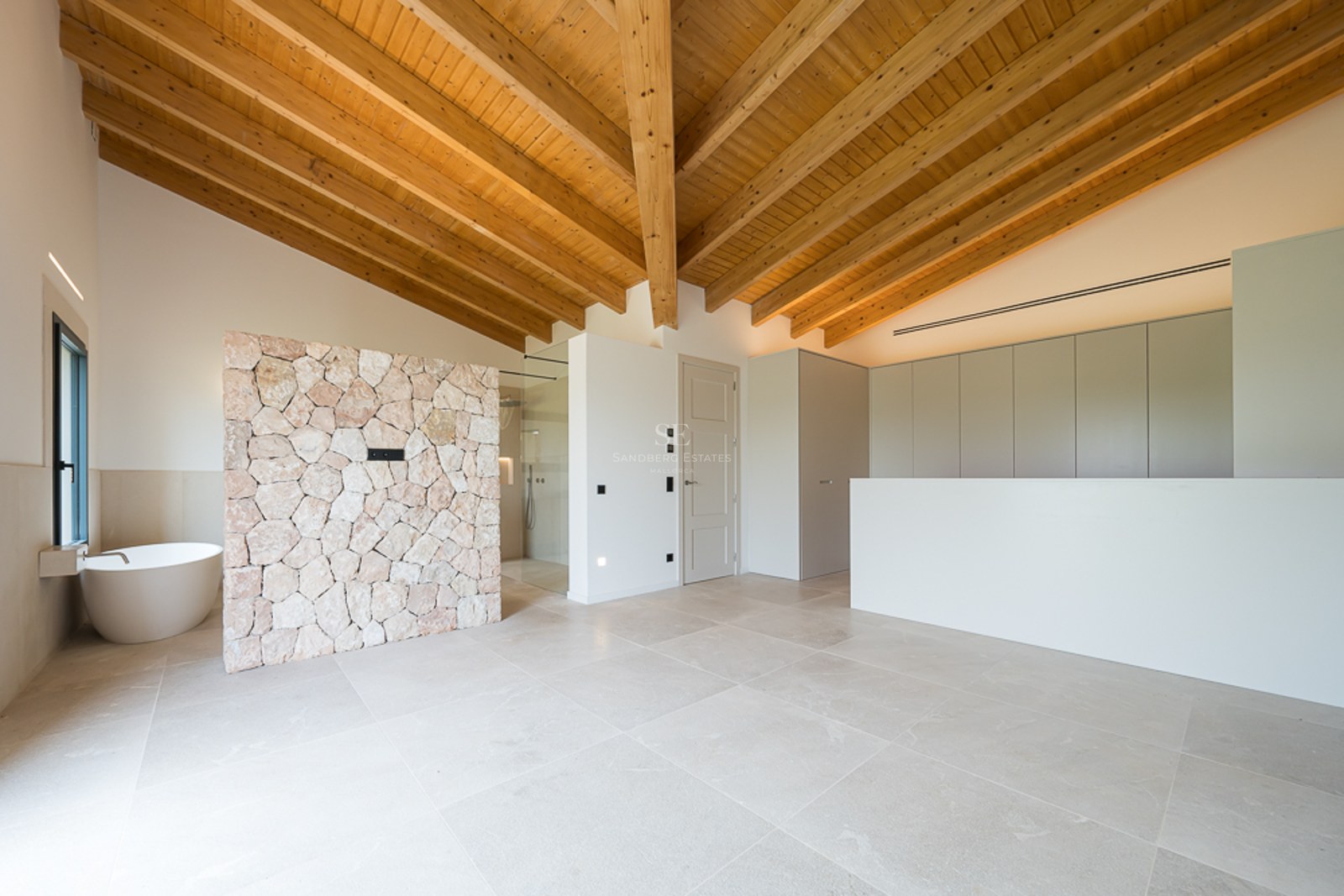 Modernes Badezimmer mit gewölbter Holzdecke, Natursteinwand und freistehender ovaler Badewanne.