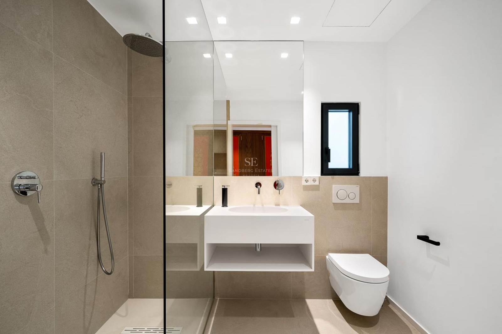 Salle de bain moderne avec douche à l'italienne vitrée, vasque suspendue blanche et carrelage beige.
