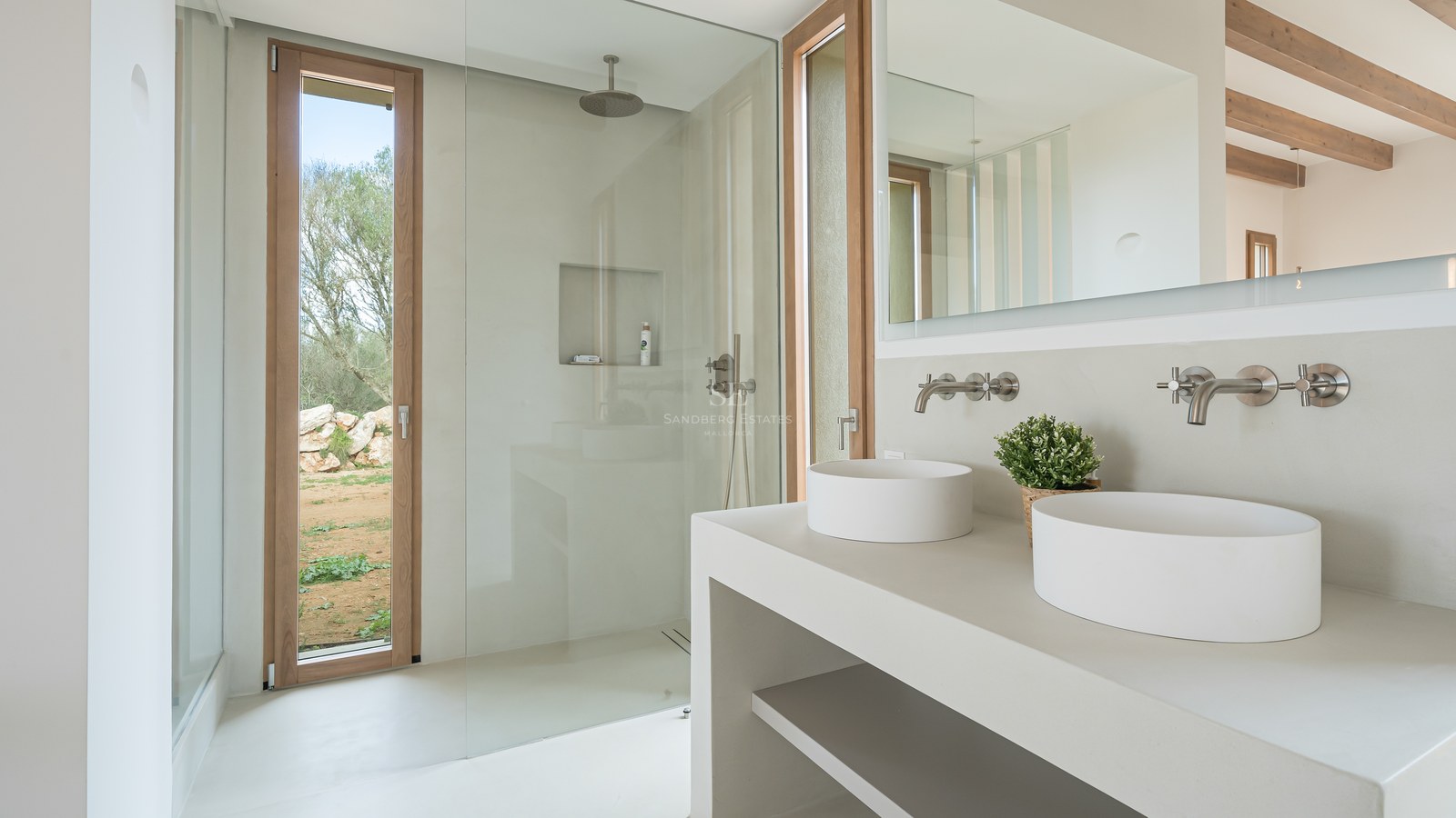 Contemporary bathroom featuring double vessel sinks, a walk-in glass shower, and light wood window frames.