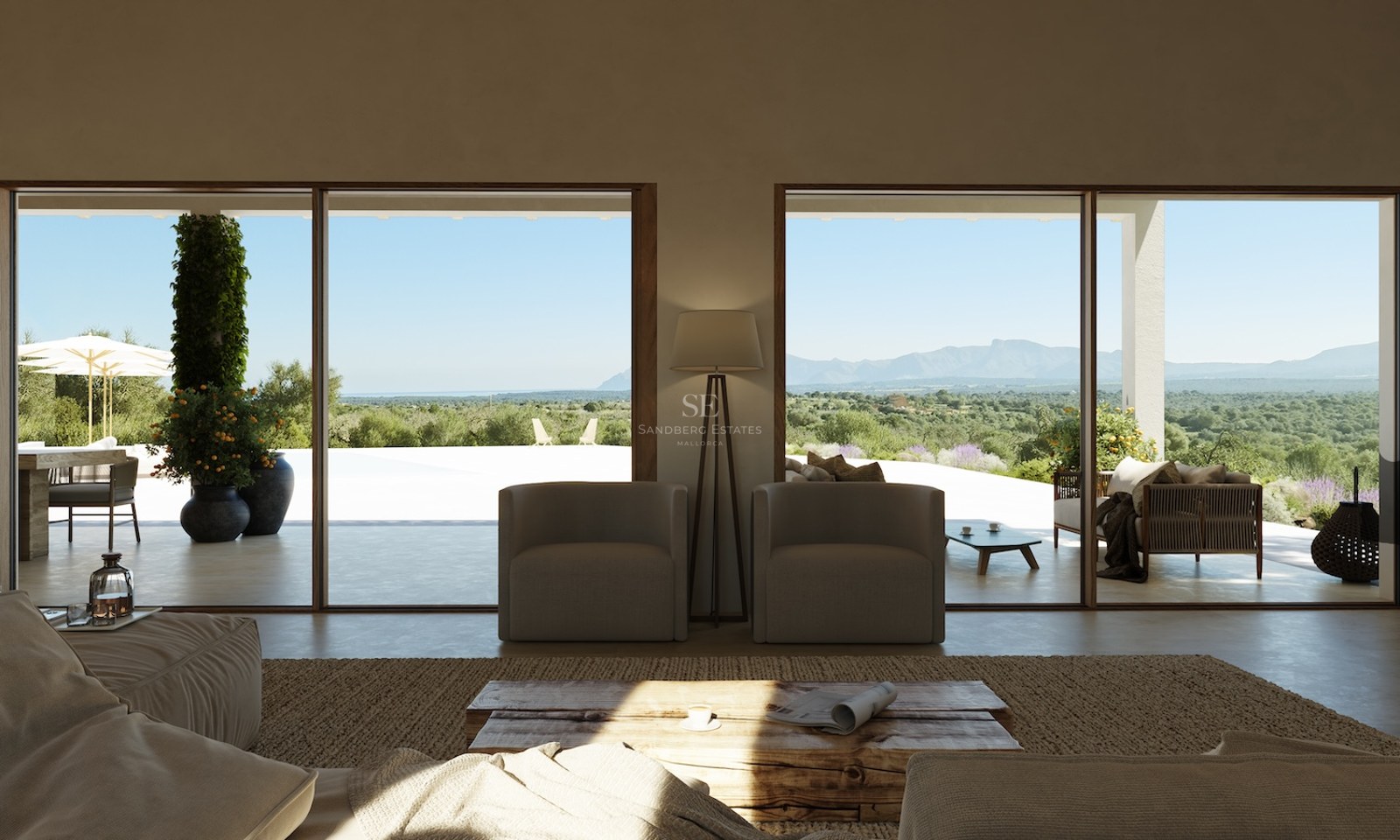 Minimalistisches Wohnzimmer mit bodentiefer Verglasung zur Terrasse mit weitem Blick über das Tal und die Berge.