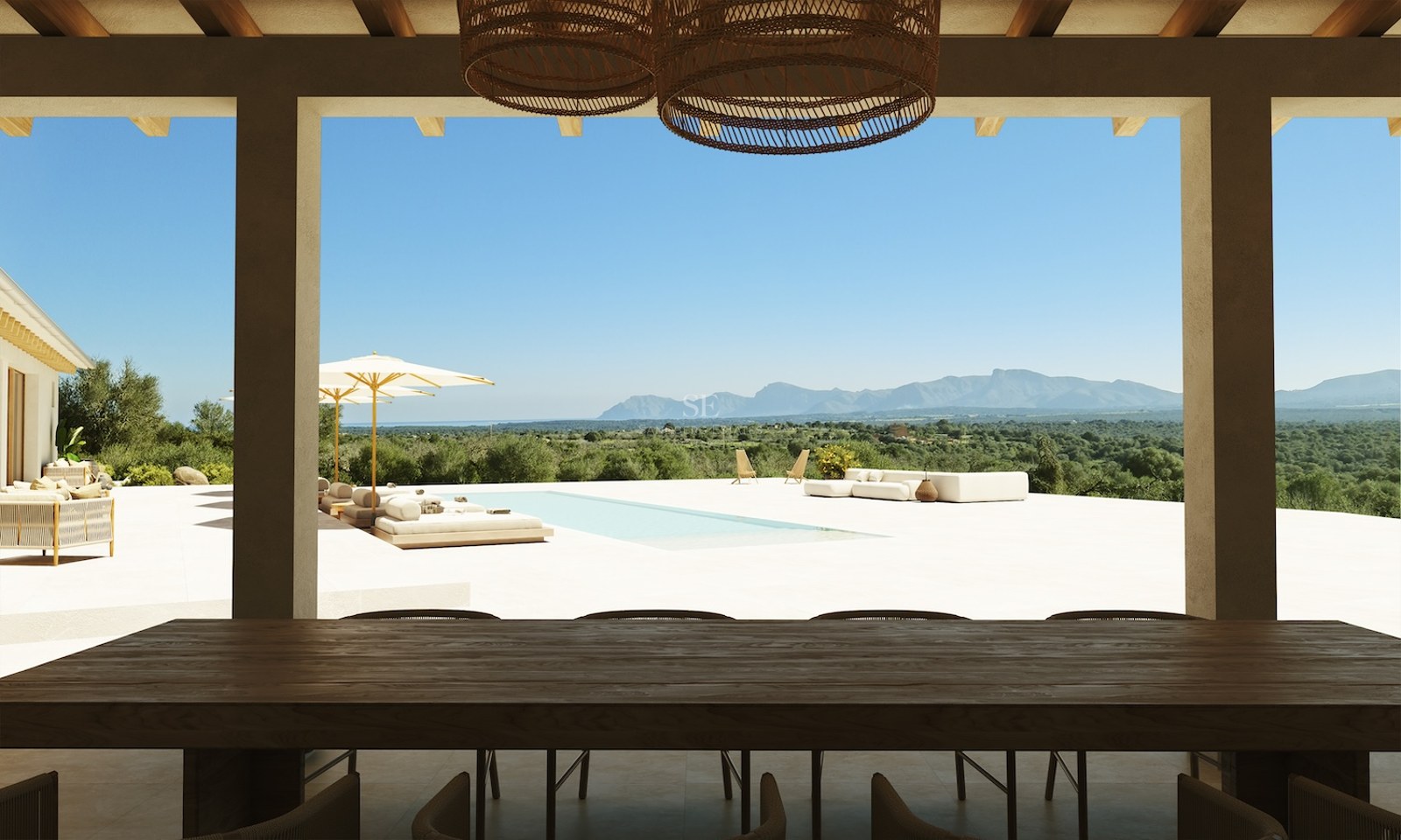 Schattige Terrasse mit dunklem Holztisch und Blick auf einen Pool und eine Bergkette unter blauem Himmel.