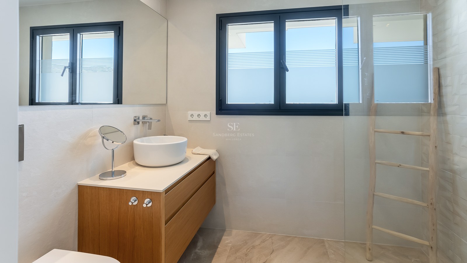 Salle de bain contemporaine avec vasque blanche sur meuble en chêne et douche vitrée.