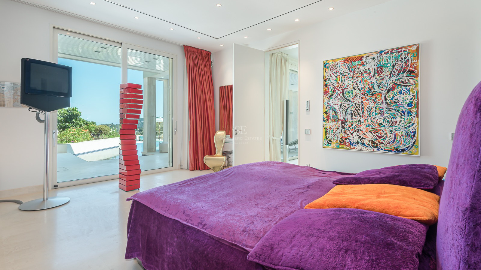 High-end master bedroom featuring purple velvet bedding, floor-to-ceiling glass doors, and contemporary art.