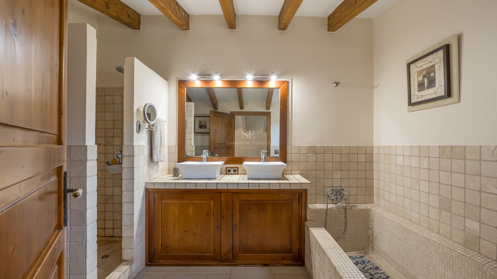 Salle de bain avec double vasque, meuble en bois, poutres apparentes, douche à l'italienne et baignoire carrelée.