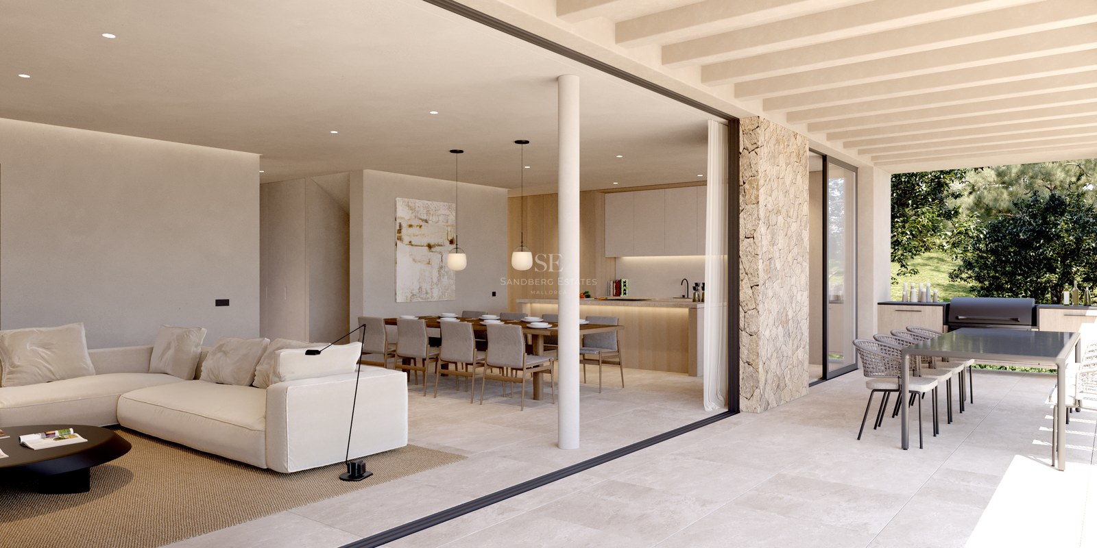 Vaste salon intérieur avec canapé blanc s'ouvrant sur une terrasse extérieure avec coin repas et cuisine.